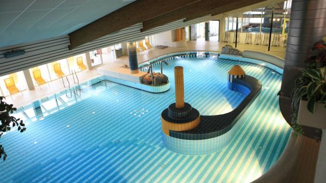 Spielbecken mit zwei Massagedüsen und langer Sitzbank in der Beckenmitte